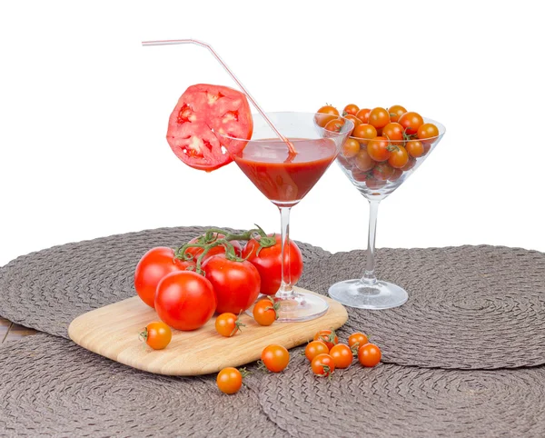 Tomatsaft i glas, orange körsbärstomater och röd tomat — Stockfoto