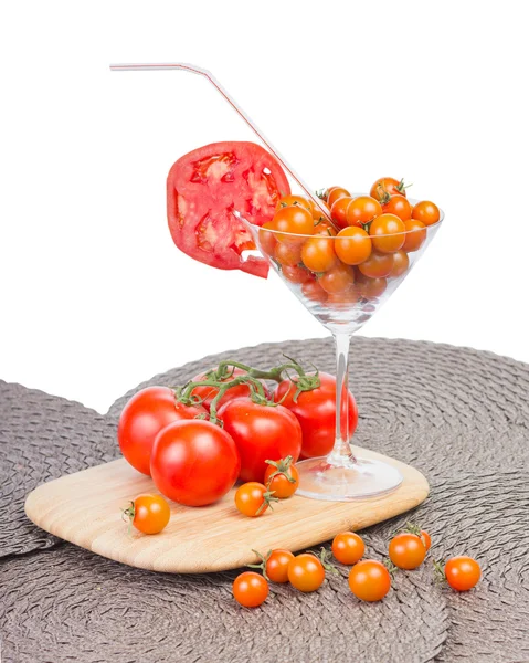 Jus de tomate dans le verre, tomates cerises orange et tomate rouge — Photo