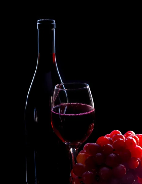Garrafa de vinho tinto, uvas e copo cheio — Fotografia de Stock
