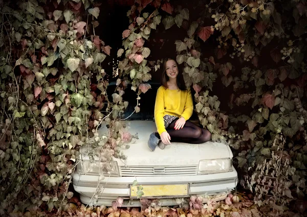 Junges Mädchen sitzt auf einem alten Auto — Stockfoto