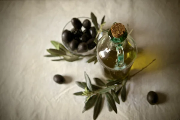 Aceitunas y una botella de aceite de oliva — Foto de Stock