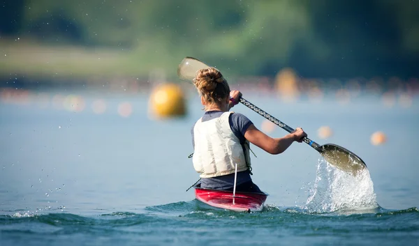 Donna Paddling Kayak nel lago Immagine Stock