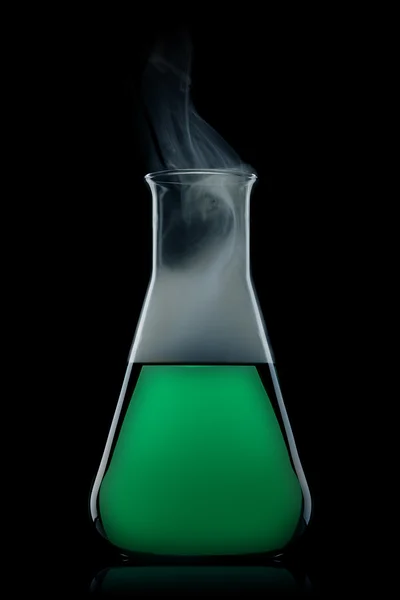 Flask with green liquid to the black background — Stock Photo, Image