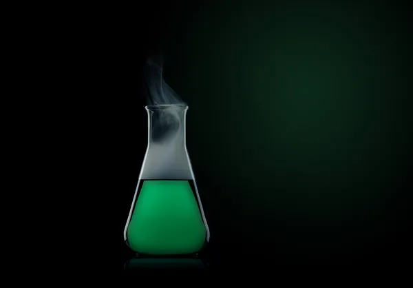 Frasco con líquido verde al fondo negro —  Fotos de Stock