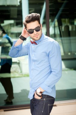 çekici genç erkek model açık havada poz mavi gömlek ve güneş gözlüğü