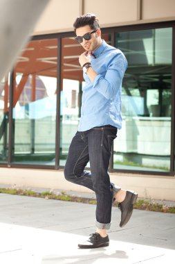 yakışıklı genç erkek model açık havada poz mavi gömlek ve güneş gözlüğü