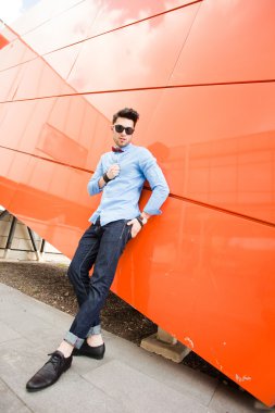 yakışıklı genç erkek model açık havada poz mavi gömlek ve güneş gözlüğü