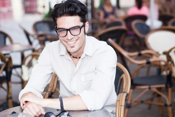 Attrayant homme portant des lunettes debout sur une terrasse — Photo