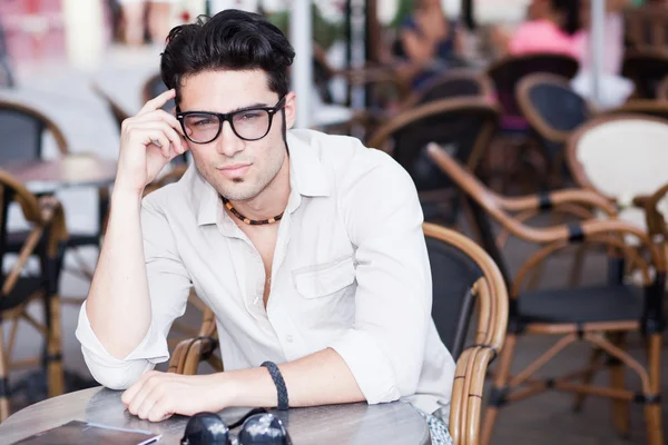 Attrayant homme portant des lunettes debout sur une terrasse regardant coo — Photo