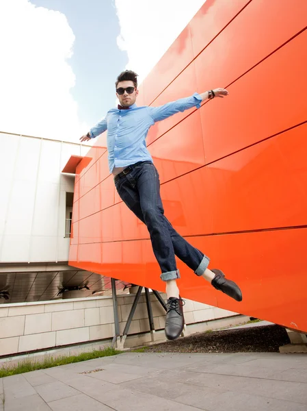Knappe jonge mannelijke model poseren buitenshuis in blauw shirt en zonnebril — Stockfoto