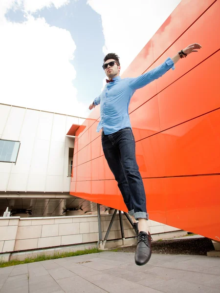 Beau jeune modèle masculin posant à l'extérieur en chemise bleue et lunettes de soleil — Photo