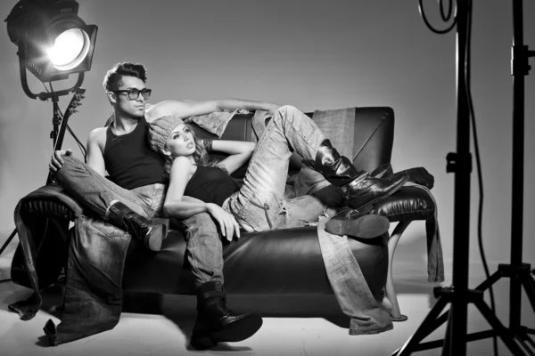 Uomo e donna sexy vestiti in jeans che fanno un servizio fotografico di moda in uno studio professionale Immagine Stock