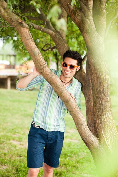 Handsome man wearing sunglasses relaxing in the park Stock Photo