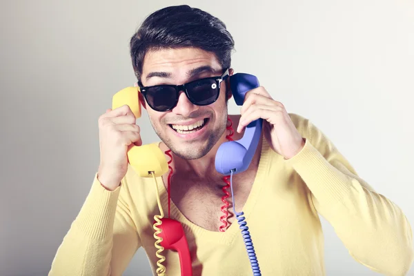 Legrační volání centrum chlap s bederní brýle a colouful telefony Stock Snímky