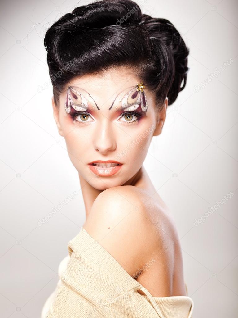 Beautiful face of young woman with fairy tale make-up