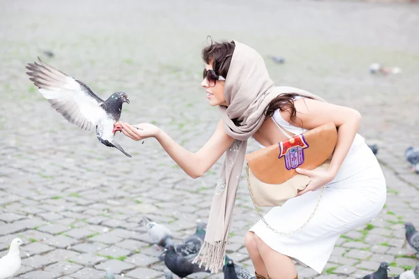 Beautiful girl holding a pigeon — Stock Photo, Image