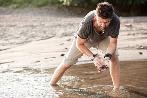 Homme cueillant des coquilles de la rivière dans de petites eaux- dans la série sauvage — Photo