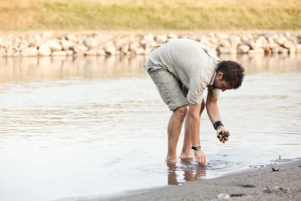 Homme à la recherche de coquillages près de la rivière dans la série sauvage — Photo