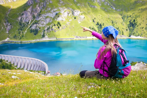 Menina bonito de pé em uma colina apontando para uma bela paisagem — Fotografia de Stock