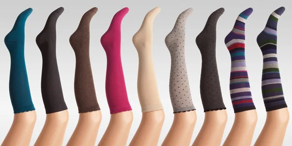Donna calze su gambe di plastica contro sfondo grigio gradiente — Foto Stock