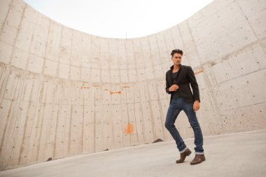 çekici erkek kot pantolon ve bot içinde bir grungy manzarası giymiş