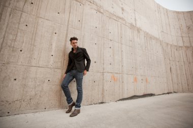 çekici erkek kot pantolon ve bot içinde bir grungy manzarası giymiş