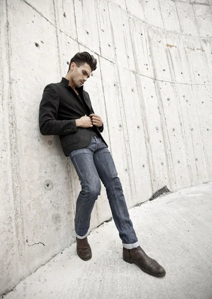 Attractive man dressed in jeans and boots in a grungy scenary Stock Picture