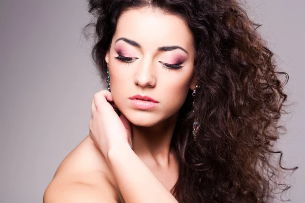 Linda chica con el pelo rizado usando maquillaje - toma de estudio —  Fotos de Stock