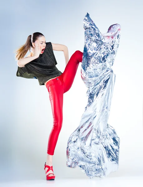Sexy model z szczupła ubrany w czerwony skoki w studio tle niebieska — Zdjęcie stockowe