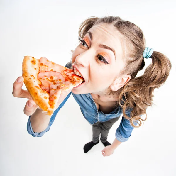 Linda chica divertida con dos colas de pony comer pizza - tiro de gran angular — Foto de Stock