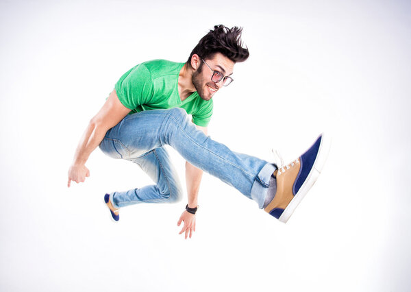 handsome man dressed casual jumping and smiling - dynamic wide