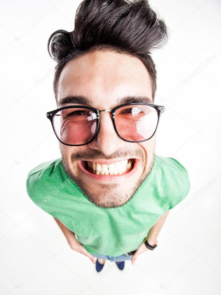 funny handsome man with hipster glasses smiling - wide angle shot
