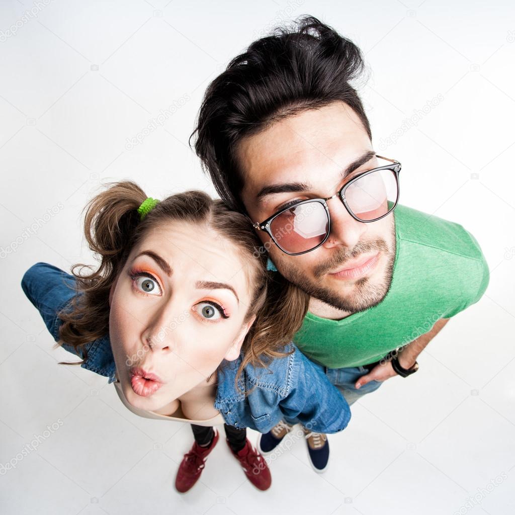 pretty couple dressed casual making funny faces - view from above wide angle shot