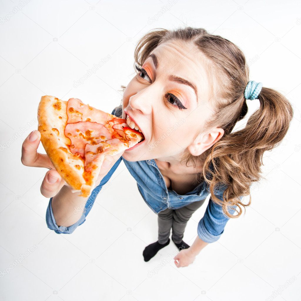 cute funny girl with two pony tails eating pizza - wide angle shot