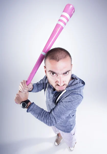 Funny hooligan with a pink baseball bat screaming in the studio — Stock Photo, Image