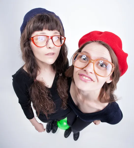 Dos chicas lindas usando gafas de la abuela divertirse y hacer caras divertidas —  Fotos de Stock