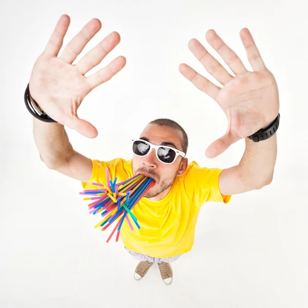 Funny man with juice straws in his mouth wearing sun glasses and yellow t shirt — Stock Photo, Image