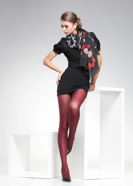 Vacker kvinna med långa sexiga ben klädda eleganta poserar i studion — Stockfoto