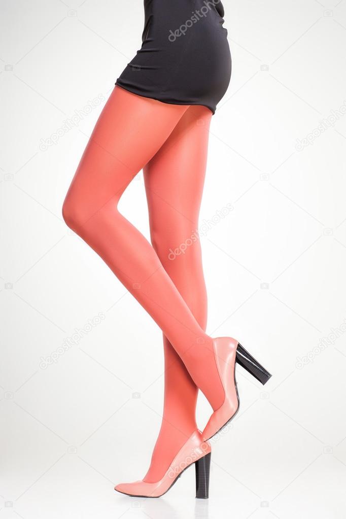 orange stockings on sexy woman legs isolated on grey