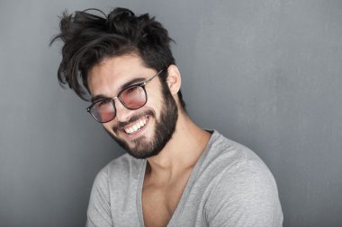 Sexy man with beard smiling big against wall clipart
