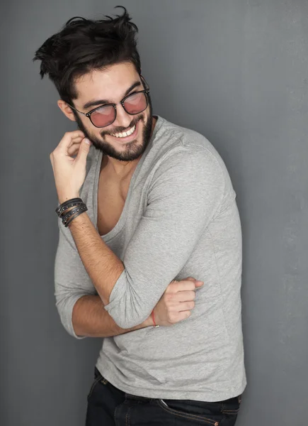 Sexy fashion man met baard gekleed casual glimlachend tegen muur — Stockfoto