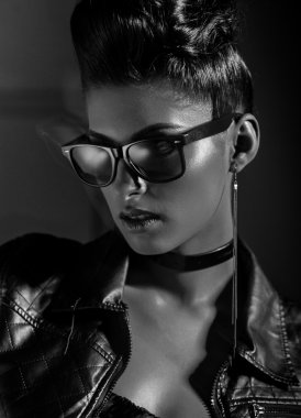 Güneş gözlüğü ve deri ceket giyen güzel bir punk kadın modeli. 