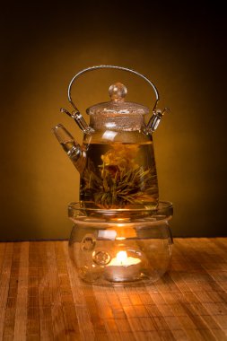 kahverengi zemin üzerine ahşap masa üstünde egzotik yeşil çay ile cam çaydanlık