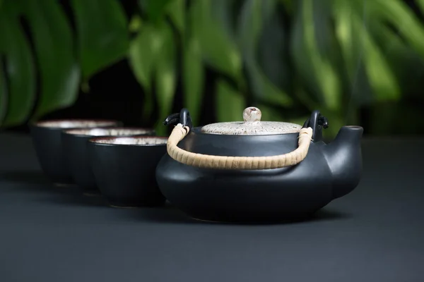 Черный керамический чайник с чашками и паром — стоковое фото