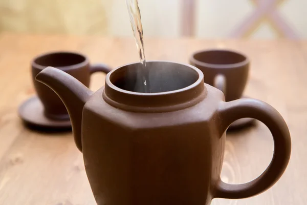 Tetera de arcilla y tazas en una mesa de madera —  Fotos de Stock