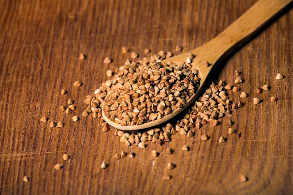 Grañones de trigo sarraceno y cuchara de madera — Foto de Stock