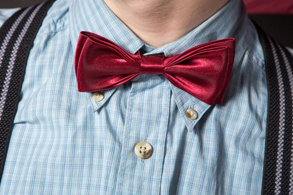 Man in a red suit and a bow tie plaid shirt on a black background — Stock Photo, Image