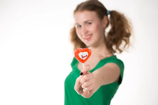 Primo piano colpo di ragazza con lecca-lecca cuore rosso isolato su bianco — Foto Stock