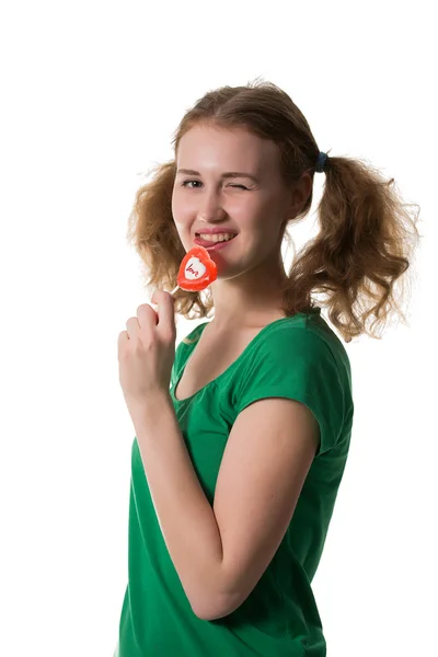 Closeup shot of girl with red heart lollipop isolated on white — Stock Photo, Image