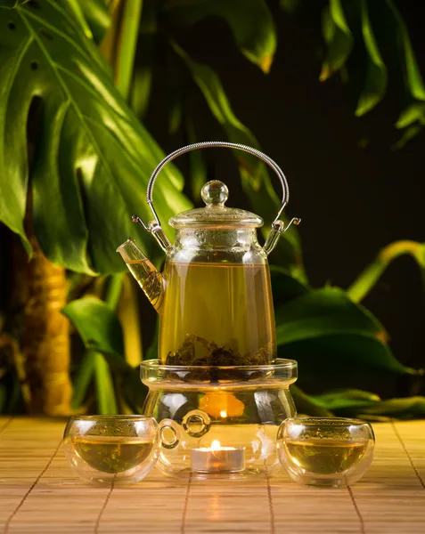 Chinesische Teekanne mit Tee, auf brennendem Untersatz aus Glas — Stockfoto